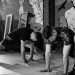 Two men stretching inside a gym, preparing for MMA training in a grayscale setting.